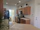 Kitchen with wood cabinets and black appliances, plus adjacent laundry room and a door to the garage at 3780 82Nd Avenue E Cir # 101, Sarasota, FL 34243
