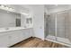 Bathroom showcasing dual sinks, a framed mirror, and a glass-enclosed shower with tiled walls at 4159 Via Sienna Cir, Sarasota, FL 34243