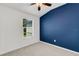 Bedroom with a dark blue accent wall, natural light from the window, and plush carpeting at 4159 Via Sienna Cir, Sarasota, FL 34243