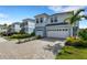 Beautiful townhome exterior featuring a paved driveway, garage, and tropical landscaping at 4159 Via Sienna Cir, Sarasota, FL 34243