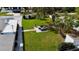 Aerial view of the backyard with outdoor seating, lush green lawn, privacy fence, and mature trees at 4218 S Lockwood Ridge Rd, Sarasota, FL 34231
