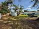 View of the spacious backyard, featuring lush green grass, a shed, and outdoor seating area at 4218 S Lockwood Ridge Rd, Sarasota, FL 34231