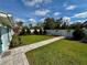 Beautifully landscaped backyard featuring a stone pathway, lush green lawn, and manicured shrubbery at 4218 S Lockwood Ridge Rd, Sarasota, FL 34231