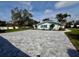 Paver driveway leading to a well-manicured lawn and a charming home with blue shutters and trim at 4218 S Lockwood Ridge Rd, Sarasota, FL 34231