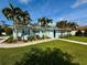 Charming home exterior with lush landscaping, palm trees, blue shutters, and manicured lawn at 4218 S Lockwood Ridge Rd, Sarasota, FL 34231