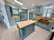 A spacious kitchen with an island, wooden floors, stainless steel appliances, and a copper farmhouse sink at 4218 S Lockwood Ridge Rd, Sarasota, FL 34231
