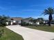 Beautiful home with a well-maintained lawn, a long driveway, and tropical landscaping at 4224 Hall St, Port Charlotte, FL 33948