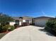 Charming home with a manicured lawn, lush landscaping, and a long driveway leading to a two-car garage at 4224 Hall St, Port Charlotte, FL 33948