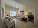 Cozy living room features vaulted ceilings, a ceiling fan, tile floors, and large windows at 4224 Hall St, Port Charlotte, FL 33948