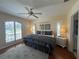 Comfortable main bedroom with a ceiling fan, hardwood floors, a large window, and natural light at 4224 Hall St, Port Charlotte, FL 33948