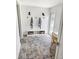 A stylish mud room area with stone floors, a bench and hooks with hanging towels, and a study area at 425 Bristol Ct, Sarasota, FL 34237