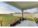 Covered patio with potted plants overlooking a spacious, fenced backyard at 4411 Hearthstone Run, Palmetto, FL 34221
