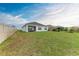 Large, grassy backyard with a view of the home's exterior and covered patio at 4411 Hearthstone Run, Palmetto, FL 34221
