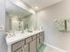 Bathroom vanity with double sinks, a large mirror, and decorative accents at 4411 Hearthstone Run, Palmetto, FL 34221