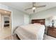 Comfortable bedroom with a large bed, classic wood furniture, and view into the tiled bathroom at 4411 Hearthstone Run, Palmetto, FL 34221