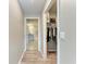 Hallway featuring a closet with organized clothing and a peek into the clean, tiled bathroom at 4411 Hearthstone Run, Palmetto, FL 34221