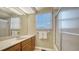 Bathroom featuring a single sink vanity with mirror, a window with blinds, and a shower-tub combo at 462 Island Cir, Sarasota, FL 34242