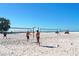 Active beach scene with people playing volleyball on a sunny day with clear blue skies in the background at 462 Island Cir, Sarasota, FL 34242