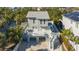 Two-story home with elevated deck, staircase, and covered parking surrounded by lush tropical landscaping at 462 Island Cir, Sarasota, FL 34242
