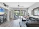 Bright living room featuring wood floors, fan and large sliding glass doors to a screened patio at 5003 88Th E St, Bradenton, FL 34211