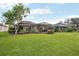 Large backyard featuring a well-manicured lawn and screened-in lanai, ideal for outdoor entertaining at 5105 Pine Shadow Ln, North Port, FL 34287