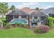 Inviting backyard with a screened-in pool area, beautiful landscaping, and outdoor seating at 5105 Pine Shadow Ln, North Port, FL 34287