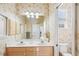 Bright bathroom featuring double sinks, floral wallpaper, and an enclosed toilet room at 5105 Pine Shadow Ln, North Port, FL 34287