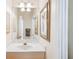 Bright bathroom features a spacious white countertop and large mirror over a wood-paneled vanity at 5105 Pine Shadow Ln, North Port, FL 34287