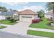 Well-maintained single-Gathering home with beautiful landscaping, a tile roof, and a brick driveway leading to the attached garage at 5105 Pine Shadow Ln, North Port, FL 34287