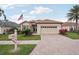 Inviting home featuring a brick driveway, lush landscaping, and a charming mailbox at 5105 Pine Shadow Ln, North Port, FL 34287