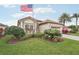 Charming home with a beautiful front yard, lush landscaping, and an American flag at 5105 Pine Shadow Ln, North Port, FL 34287