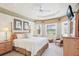 Inviting main bedroom featuring a tray ceiling, neutral carpet, and views of the golf course at 5105 Pine Shadow Ln, North Port, FL 34287
