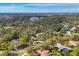 An aerial view shows the property surrounded by lush trees, a lake, and other community homes at 5416 Ashley Pkwy, Sarasota, FL 34241