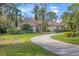 Lovely home featuring a long, curved driveway, mature landscaping and a tile roof at 5416 Ashley Pkwy, Sarasota, FL 34241