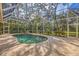 Enclosed pool with brick deck surrounded by trees at 5416 Ashley Pkwy, Sarasota, FL 34241