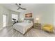 Well-lit bedroom with modern ceiling fan, stationary bike, and beach-themed art at 5591 Cannes Cir # 403, Sarasota, FL 34231