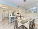 Dining room with a glass table, seating for six, and modern light fixture at 5591 Cannes Cir # 403, Sarasota, FL 34231