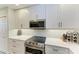Close-up of modern oven and stovetop with stainless steel microwave above at 5591 Cannes Cir # 403, Sarasota, FL 34231