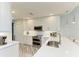 White kitchen featuring quartz countertops and stainless steel appliances at 5591 Cannes Cir # 403, Sarasota, FL 34231