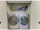 Convenient laundry room featuring a Whirlpool washer and dryer set with storage shelves at 5591 Cannes Cir # 403, Sarasota, FL 34231