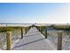 Boardwalk leading to beautiful beach with white sand and blue skies at 5665 Midnight Pass Rd # 410, Sarasota, FL 34242
