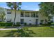 Charming condo exterior featuring a covered porch, verdant landscaping, and a brick walkway at 5665 Midnight Pass Rd # 410, Sarasota, FL 34242
