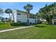Well-manicured condo exterior with lush landscaping, a covered porch, and verdant trees at 5665 Midnight Pass Rd # 410, Sarasota, FL 34242