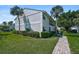 Well-maintained condo building with mature landscaping and brick pathway at 5665 Midnight Pass Rd # 410, Sarasota, FL 34242