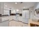 Bright kitchen with white cabinets, modern appliances, and tiled backsplash provides a clean cooking space at 5665 Midnight Pass Rd # 410, Sarasota, FL 34242