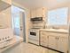 A compact kitchen featuring white cabinetry, essential appliances and a window for natural light at 5904 Palm Ln # C23, Bradenton, FL 34207