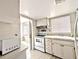 Traditional kitchen with white cabinets, tile backsplash, and a view to the entry door at 5904 Palm Ln # C23, Bradenton, FL 34207