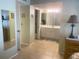 Bright bathroom with a vanity and tile flooring, featuring an open doorway and neutral paint at 6157 Midnight Pass Rd # E42, Sarasota, FL 34242