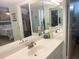 Bright bathroom featuring a double mirror over a white vanity, with a view into a closet and bedroom at 6157 Midnight Pass Rd # E42, Sarasota, FL 34242