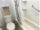 Cozy bathroom with a white tiled shower/tub combination and a decorative shelf above the toilet at 6157 Midnight Pass Rd # E42, Sarasota, FL 34242